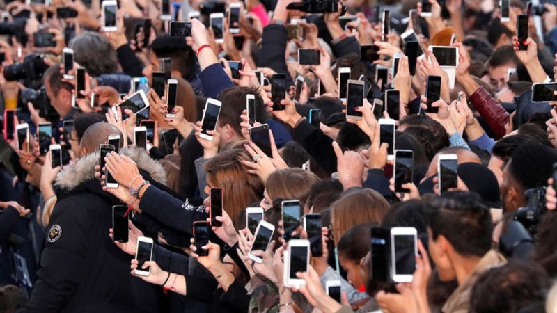 People Use Their Smartphone To Take Photos On The Champs Elysees Avenue During A Public Event In Paris