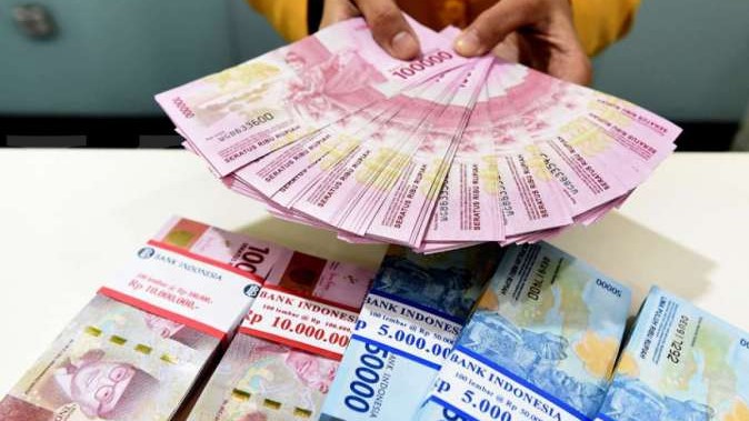 Seorang Teller Bank Mandiri Menunjukkan Uang Pecahan Rp100.000 Dan Rp50.000 Di Plasa Mandiri, Jakarta, Senin (8/7/2019).